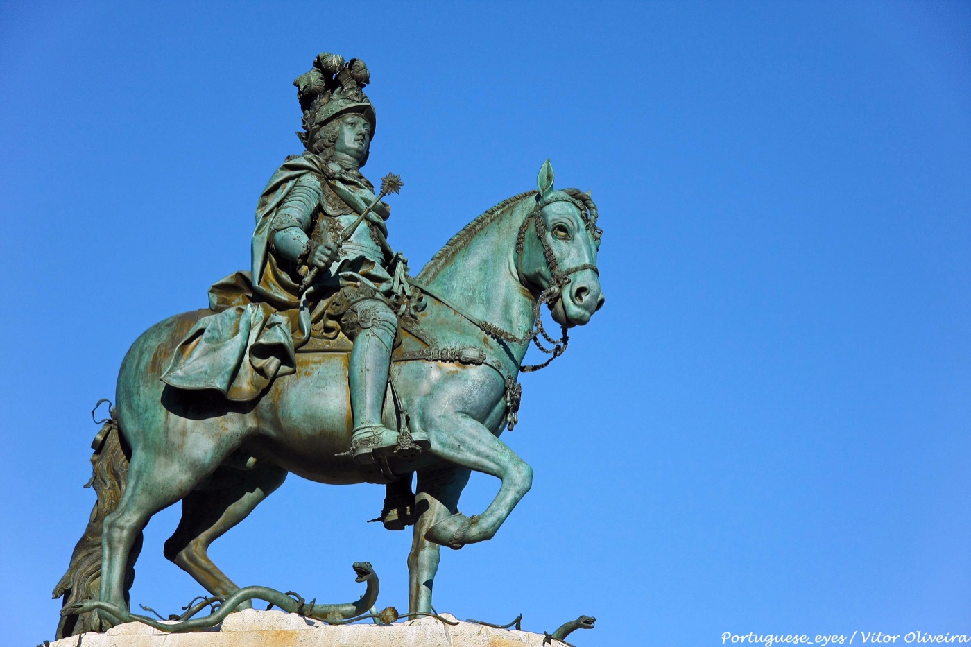 The bronze horse and King José I in Praça do Comércio, photographed against a blue sky
